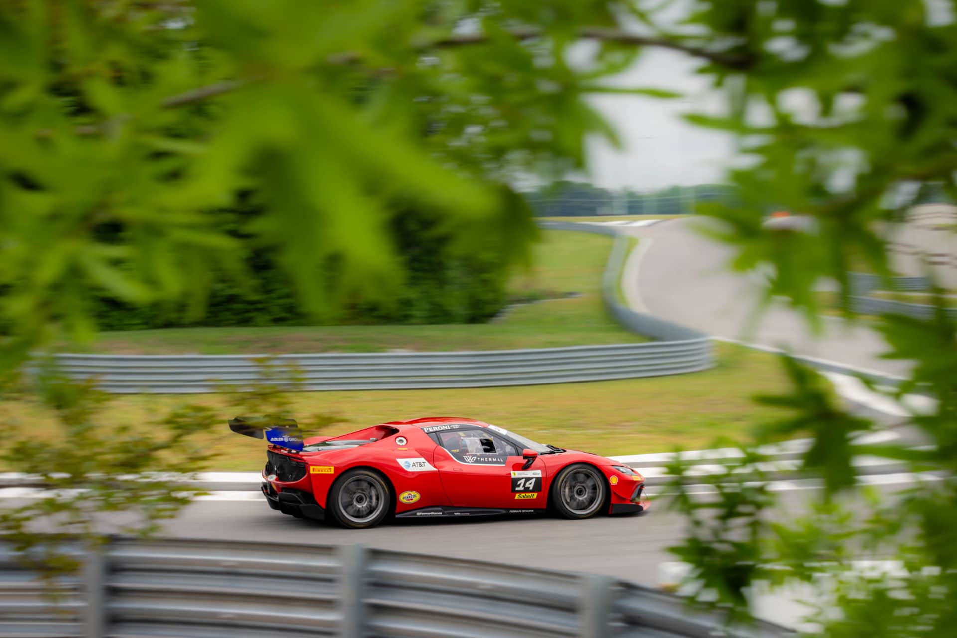 Ferrari 296 Challenge #14 at full speed on track at Ten Tenths Motor Club u2014 motion blur, green surroundings