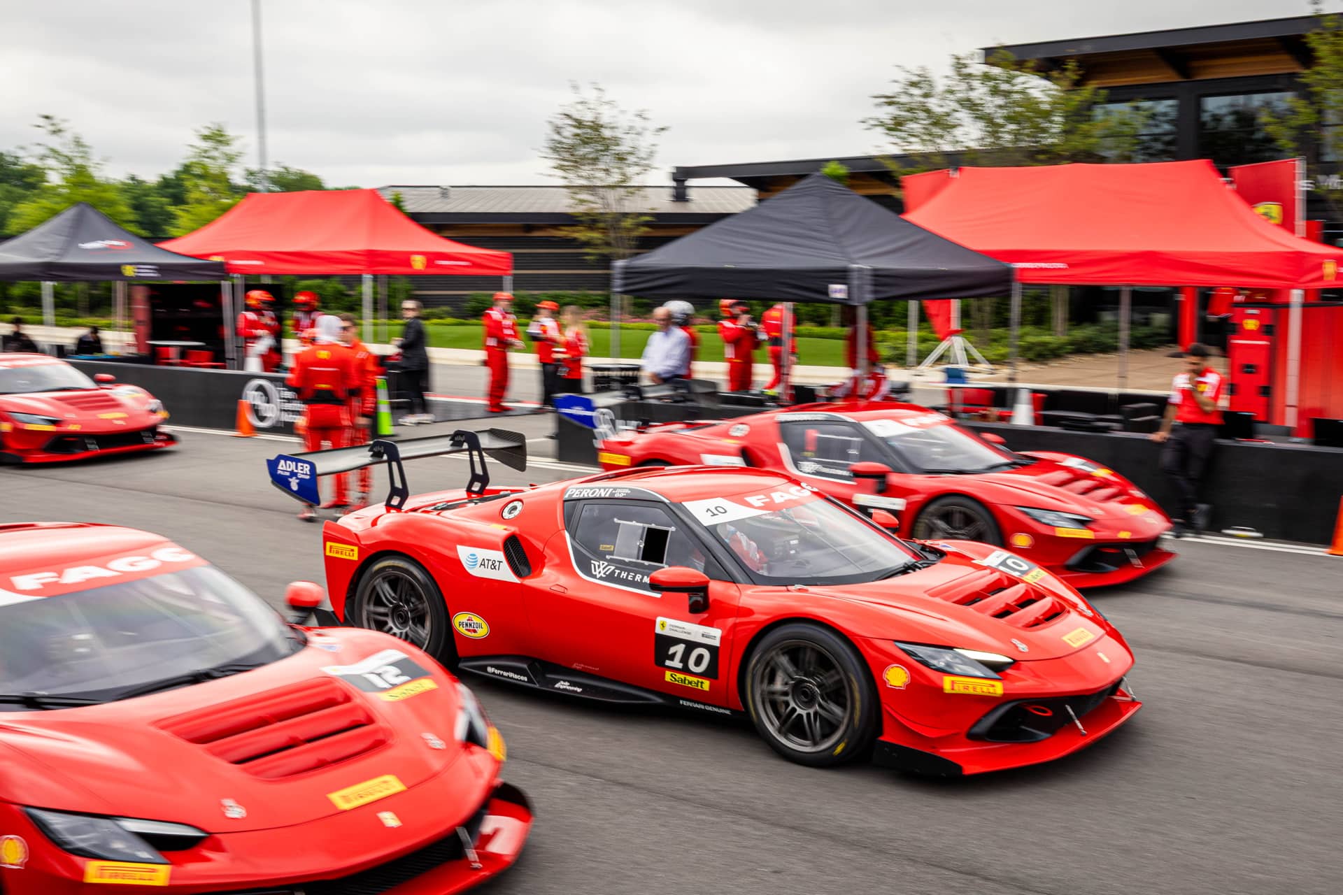 Ferrari 296 Challenge cars rolling out of pit lane at Ten Tenths