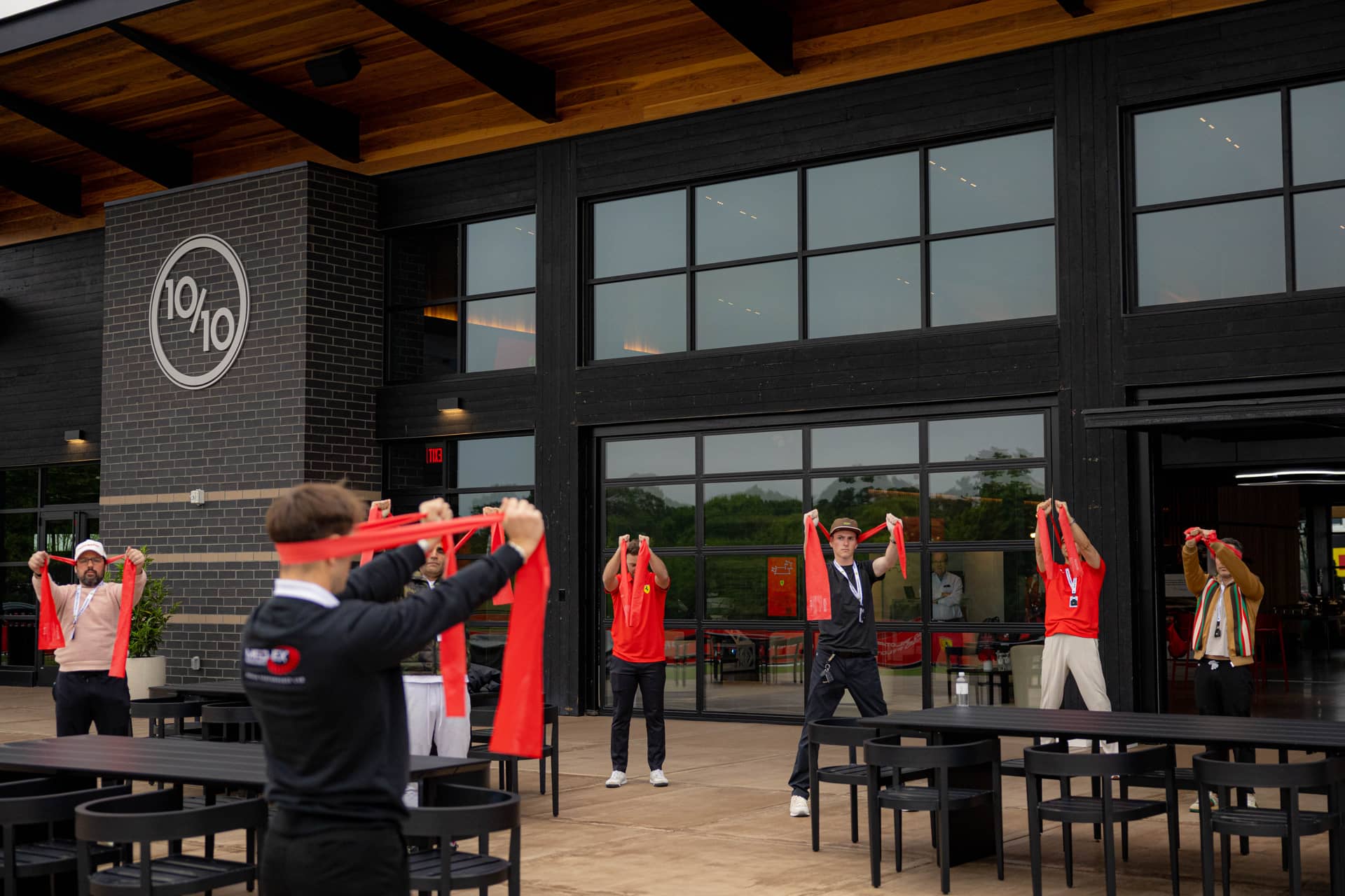 Physical warm-up session in front of Ten Tenths clubhouse - 10/10 logo visible on building